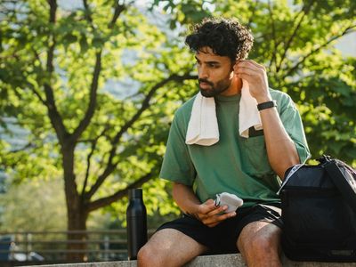 A bottle of water and a towel on a bench.