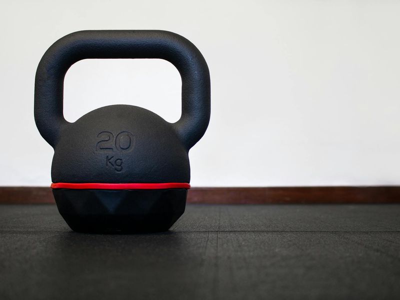 Close up of a heavy kettlebell on a wooden floor.